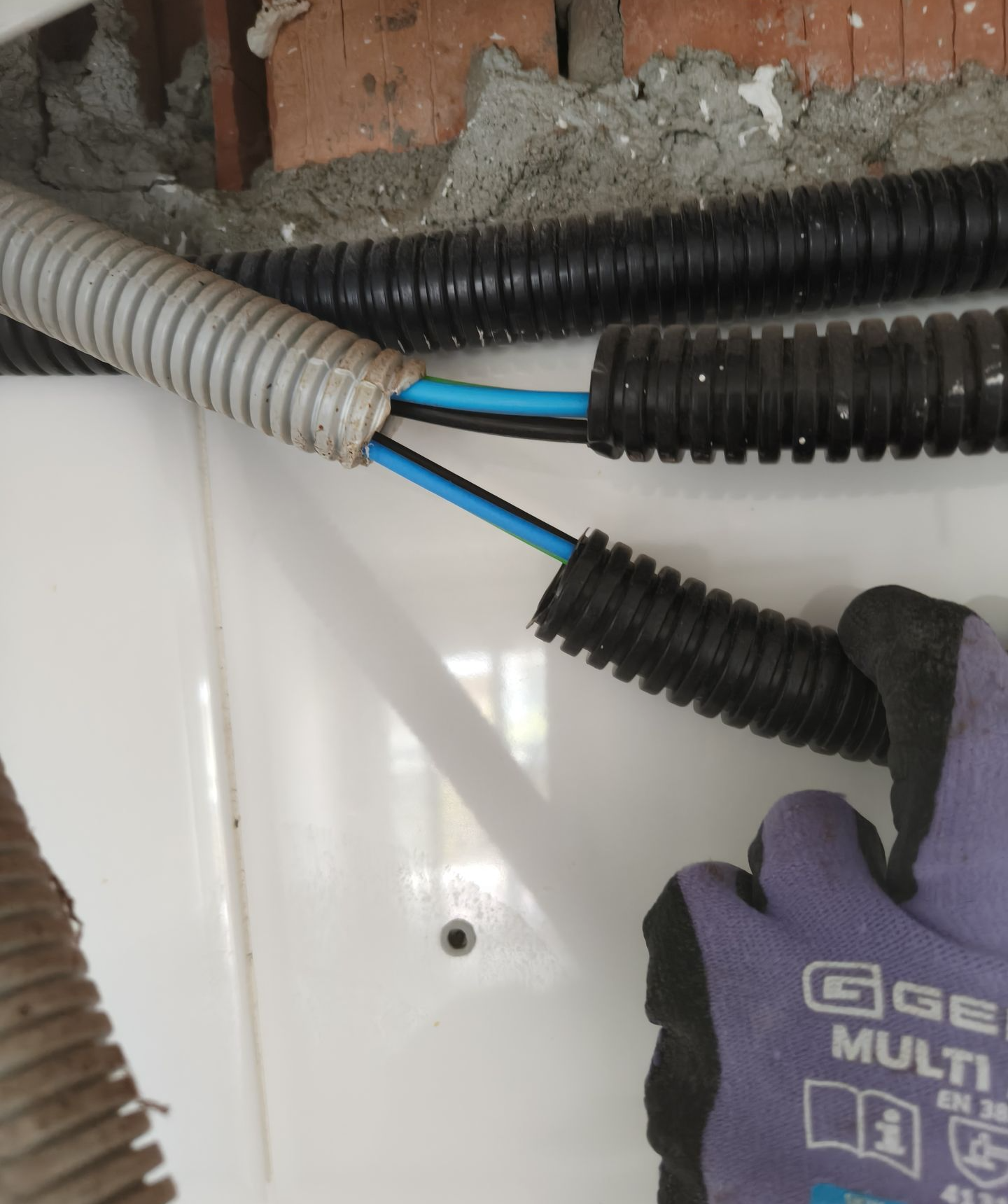 Dos tubos corrugados unidos incorrectamente en una instalación eléctrica de cocina en una vivienda de Amposta.